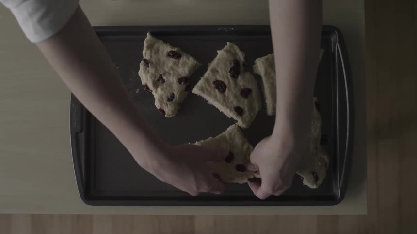 Woman places food on a tray to put in the oven
