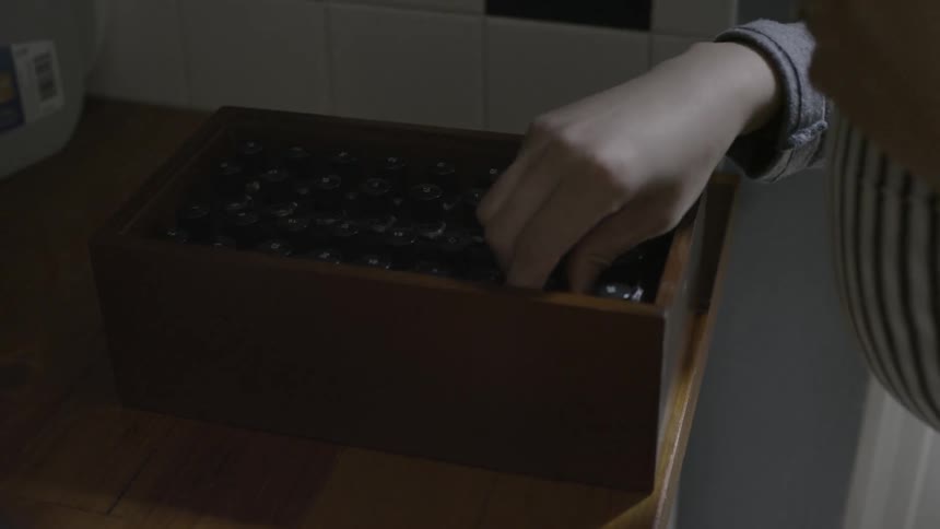 Person picks up small bottles with clear fluid