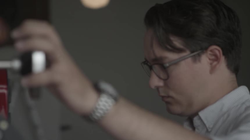 Man holds silver knob of a machine