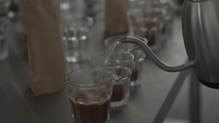 Hot water is poured into glasses to make coffee drinks
