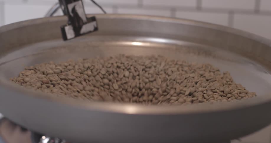 Beans fall into a metal machine cylinder