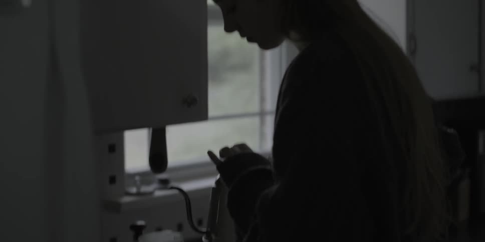 A woman makes coffee in a kitchen
