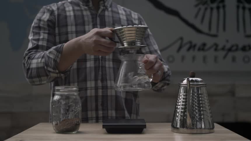 A man puts a filter on a coffee pot