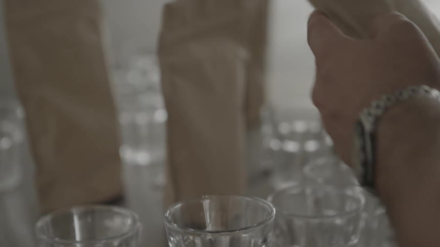 Person pours coffee beans into a glass