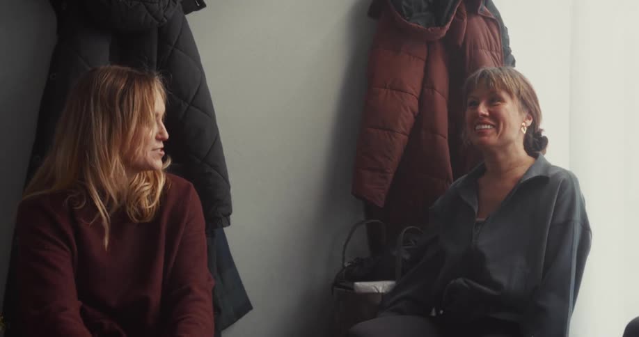Mothers gather and chat in the hallway of a community center before their class