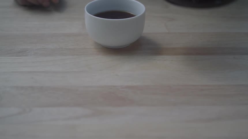 Coffee is poured into a white mug and pushed forward