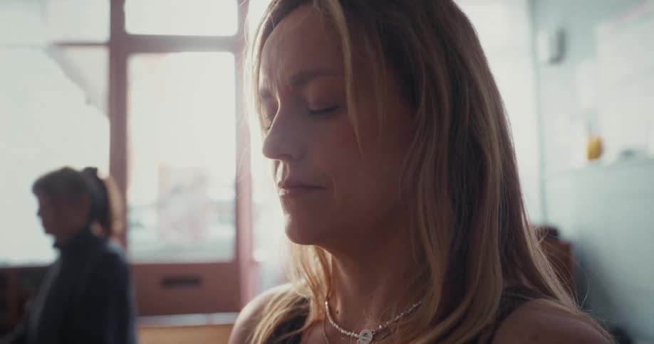 Calm woman with eyes closed meditates peacefully in a softly lit room