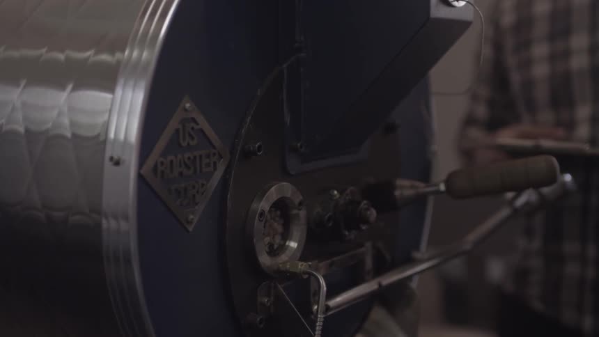 Coffee beans spin in an industrial roaster