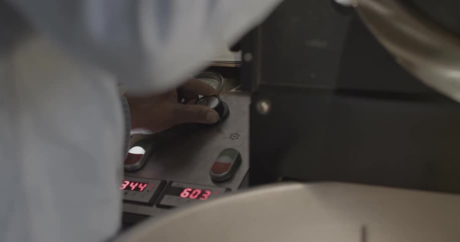A person turns the dial on a machine