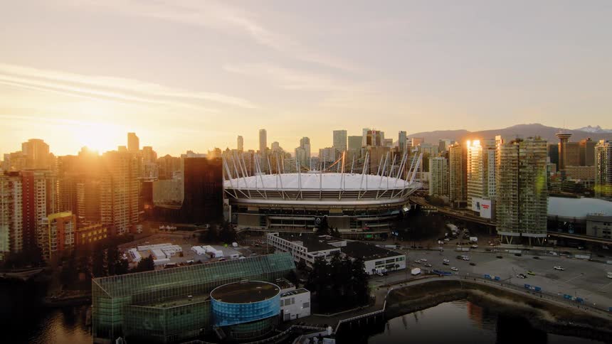 Stunning aerial pull-back reveals BC Place stadium and the Vancouver skyline illuminated by a beautiful golden sunset