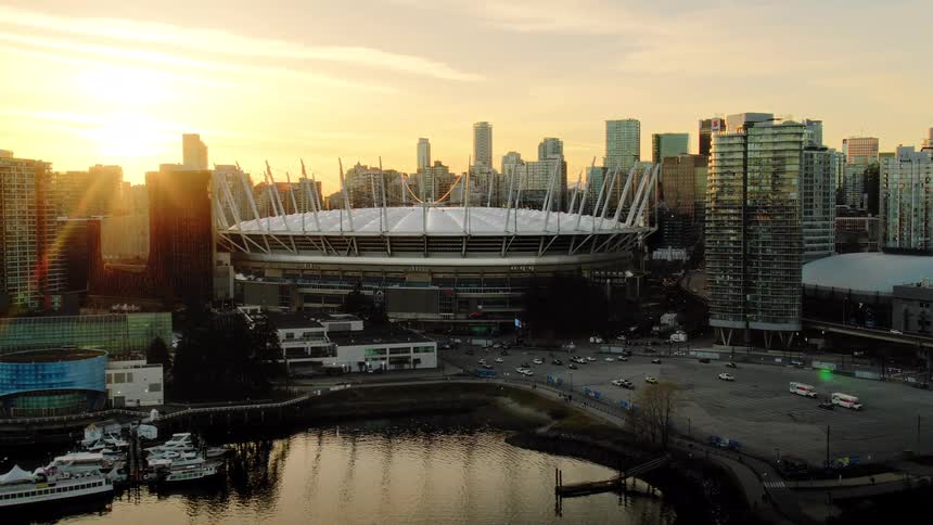 Golden sunset illuminates the Vancouver city skyline and BC Place stadium in a beautiful aerial retreat