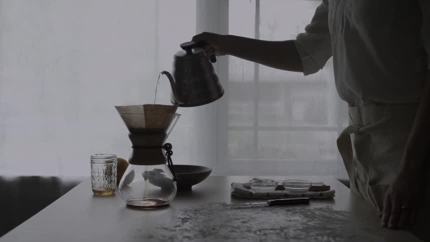 A man pours water into a filter on a pitcher