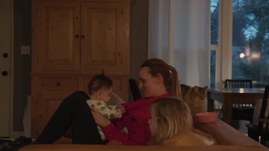 A happy mother playfully lifts her baby, touching foreheads and making silly faces that cause the infant to laugh with joy