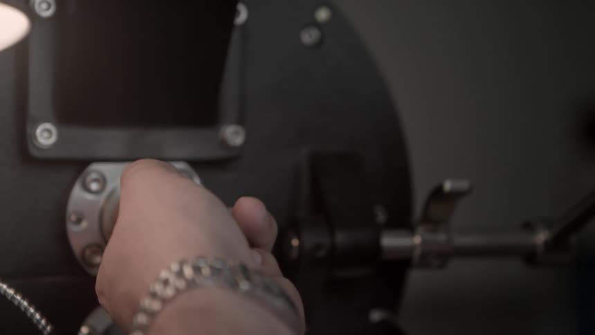Person stops a spinning knob on a machine