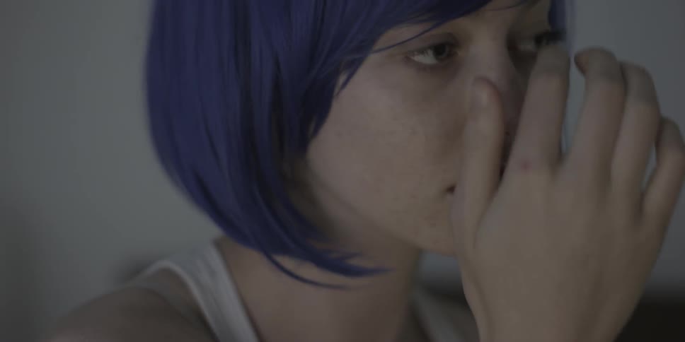Woman wearing short purple wig is fixing and adjusting the wig