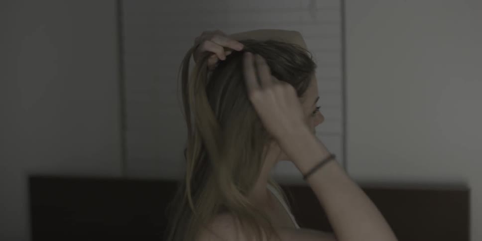 A woman is braiding her hair
