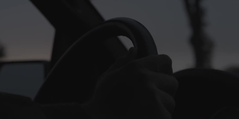 A person steers a car