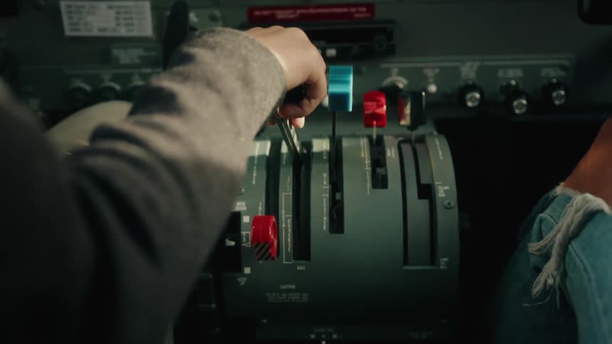 A pilot's steady hand on the throttle levers inside the cockpit of a small airplane