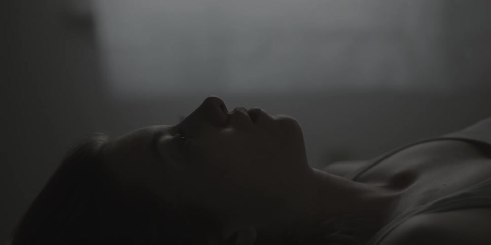 A woman is laying in bed with her eyes open