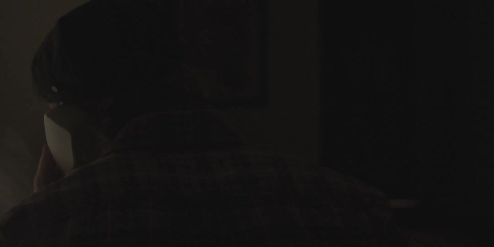 Man on the telephone in dark bedroom