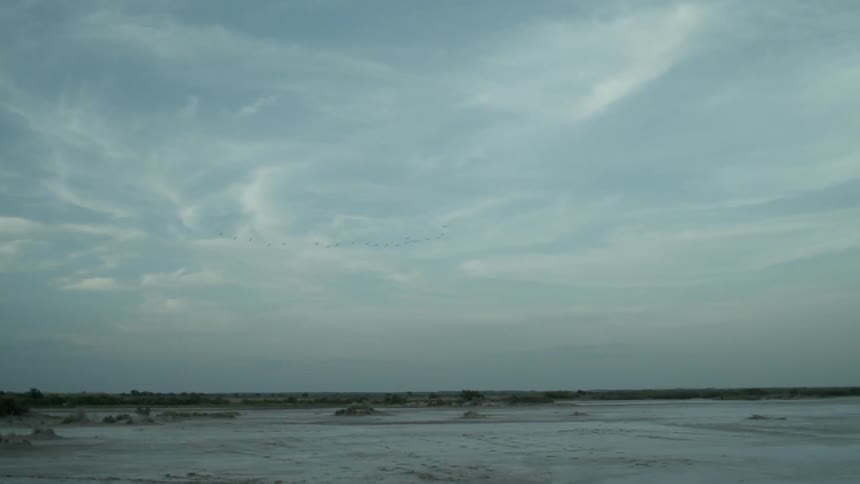 View of barren land on a cloudy day