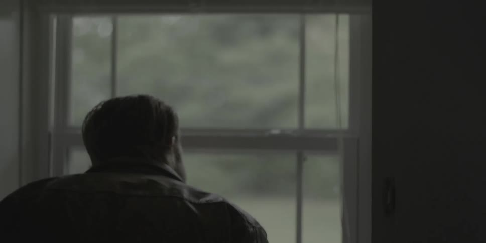 Man walks through living room to look out a window