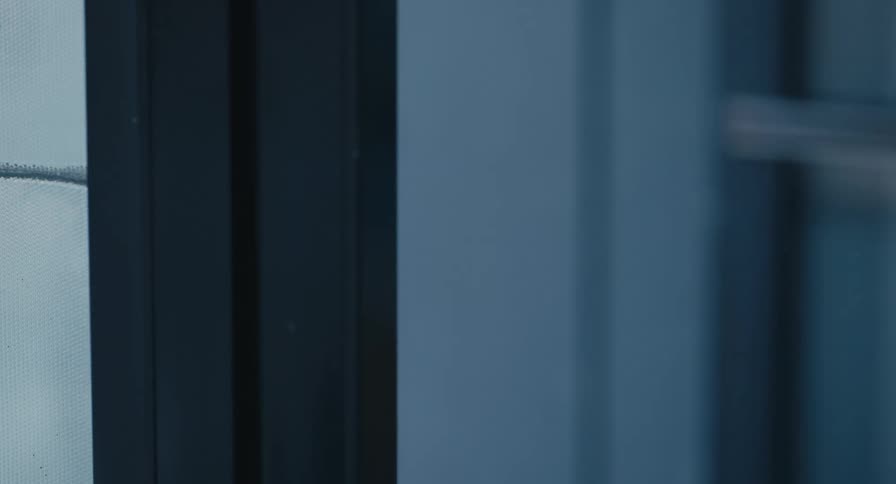 A person opens a glass door in a dark setting, followed by another person, both carrying reusable water bottles