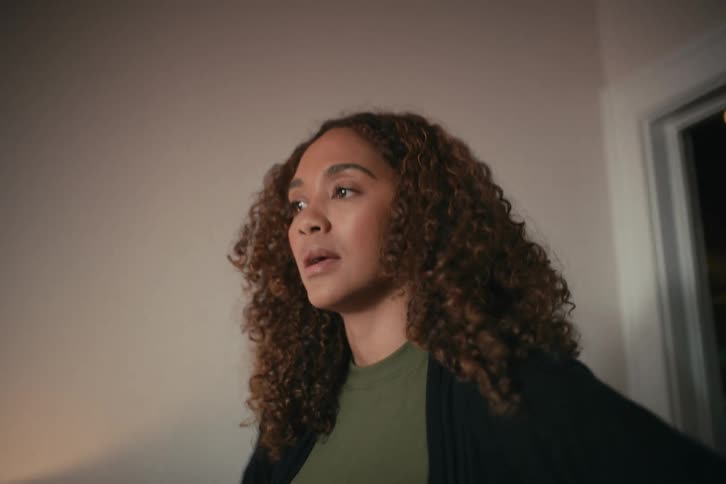 An emotional woman with curly hair passionately expresses her frustration during a heated argument