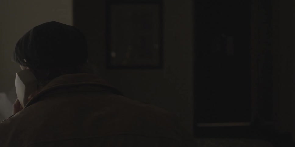 Man on the telephone in dark bedroom