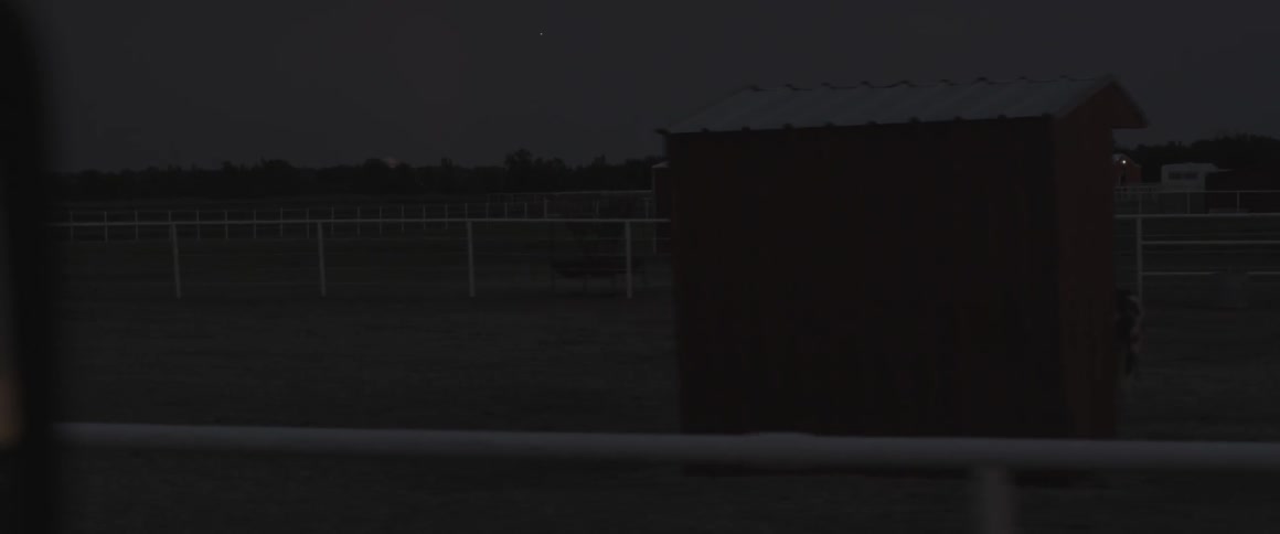 A car drives in a rural area at night