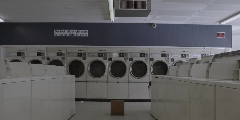 Washers and dryers are shown in a laundromat