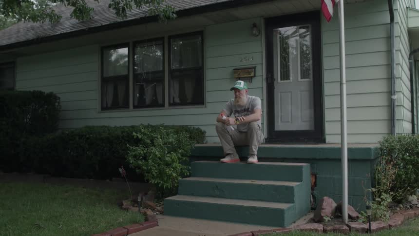 Older man sits on his porch