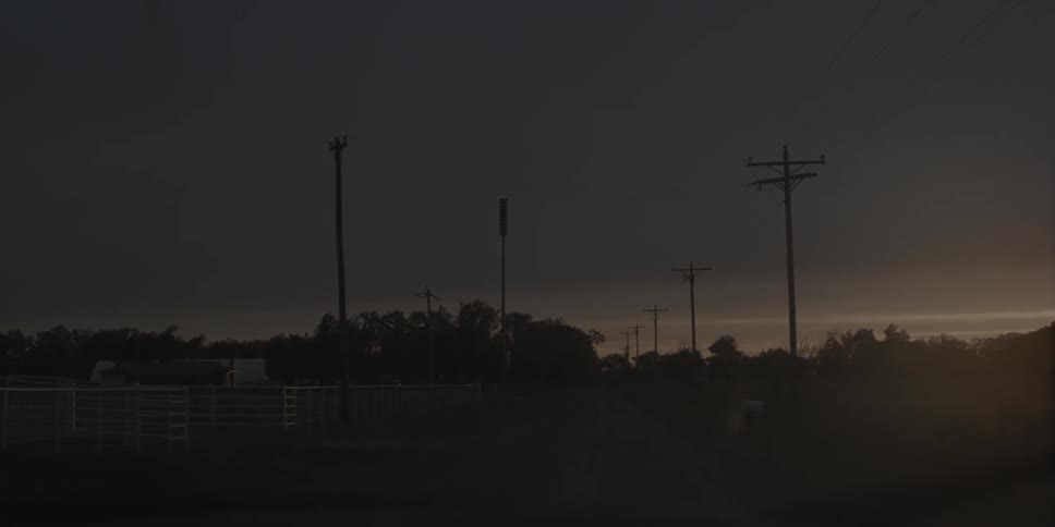 The field is lined with power lines at dawn