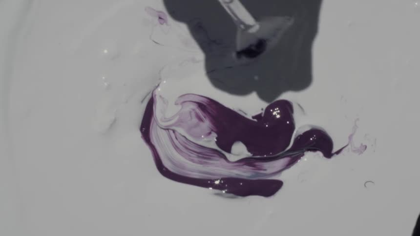 Artist mixes dab of purple paint into large areas of white paint