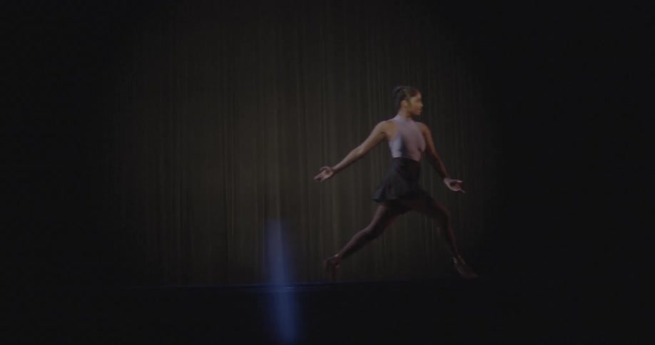 A ballerina leaps on stage