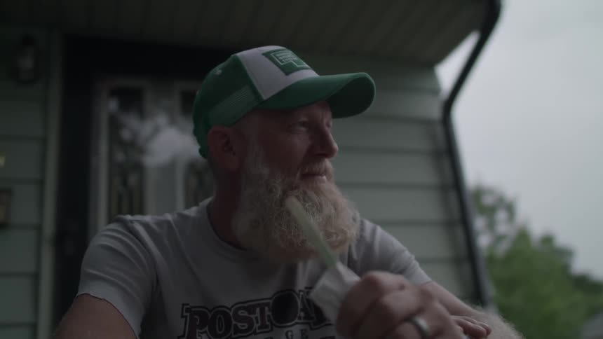 Elderly man sits on the front porch