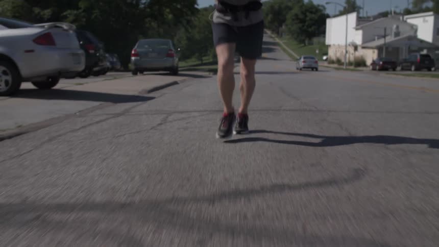 A man in shorts jogs down the road