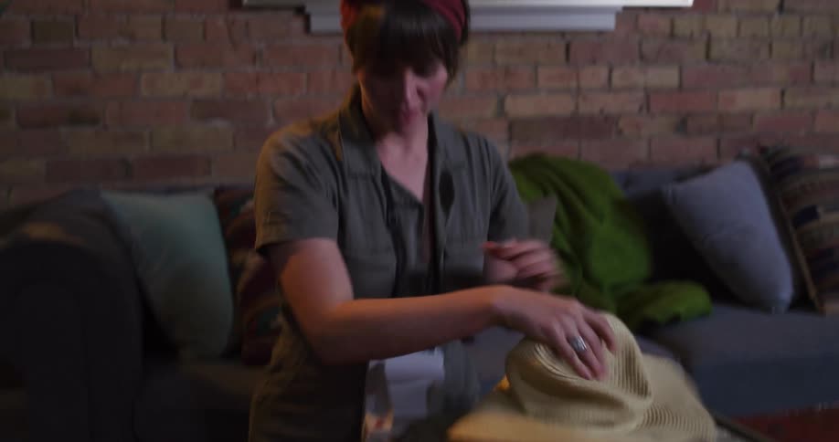 An adventurous young woman packs her vintage suitcase with travel clothes and a hat before heading out on a trip