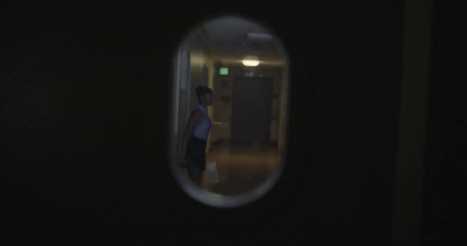 The window of the door shows a woman stretching in the hall