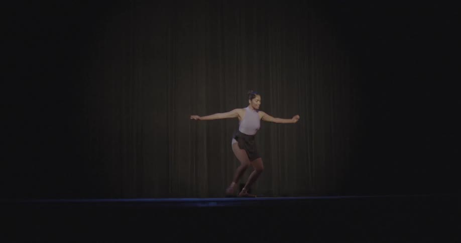 A young ballerina performing on stage