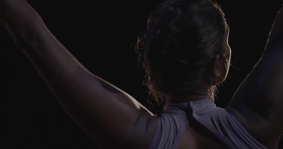 A spot light shines on a woman dancing