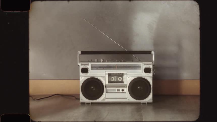 A classic 1980s boombox is featured with a vintage Super 8 film effect, complete with light leaks and film grain