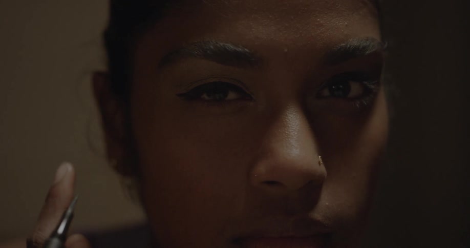 A woman applies eyeliner