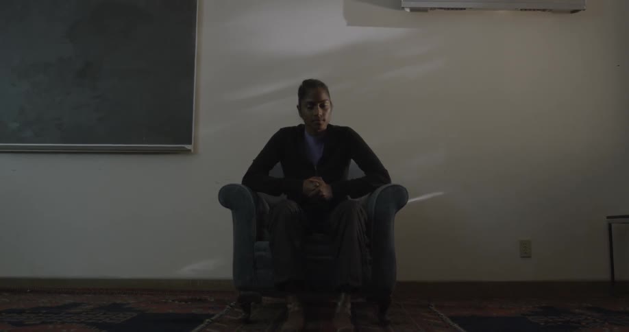 A woman sits in a chair indoors