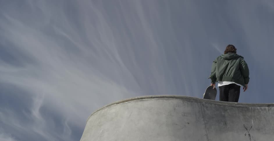A skateboarder skates up the wall and jumps to the top
