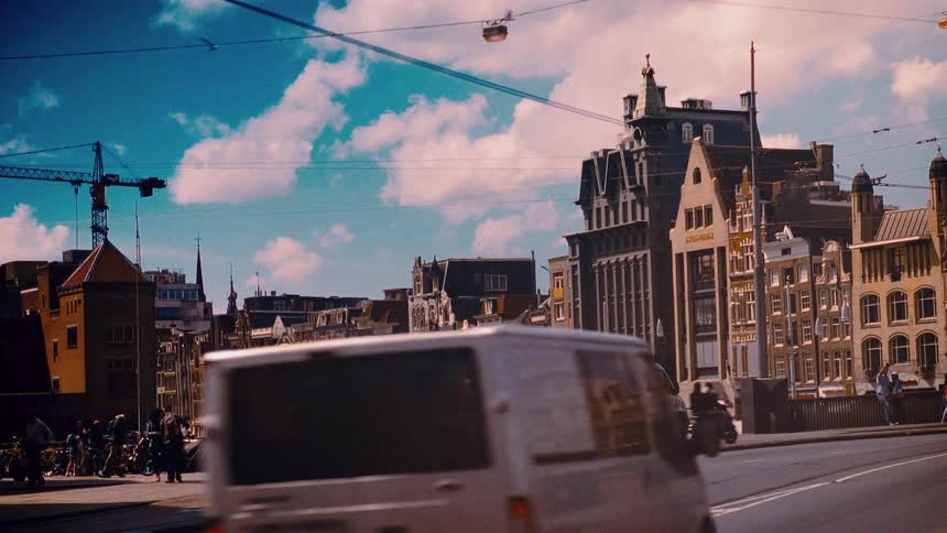 Slow motion captures the vibrant city life on a sunny street in Amsterdam, Netherlands