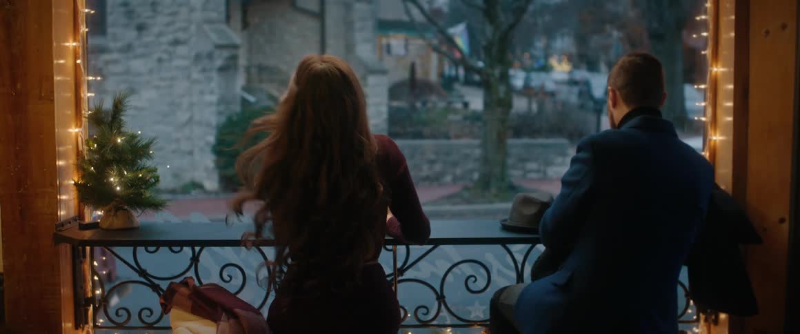 Rear view of a stylish man and woman on a date in a coffee shop, sitting at the window on a chilly day
