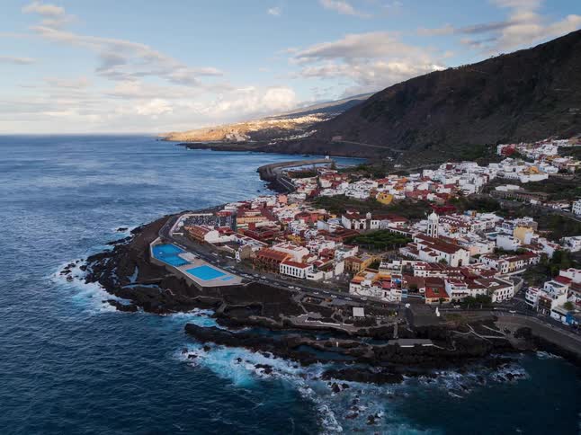 A beautiful aerial time-lapse of the sun setting over the scenic coastal town of Garachico in Tenerife, Canary Islands