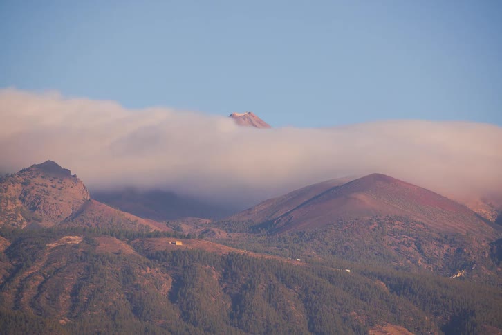 A stunning time-lapse shows clouds moving over a volcanic mountain range, with the peak of Mount Teide appearing and disappearing