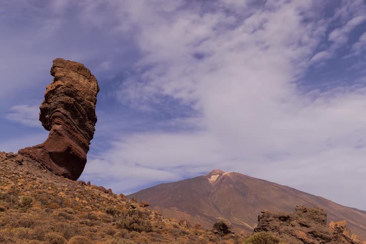 A time-lapse of clouds moving over the Roque Cinchado rock formation with the Mount Teide volcano in the background in Tenerife, Canary Islands
